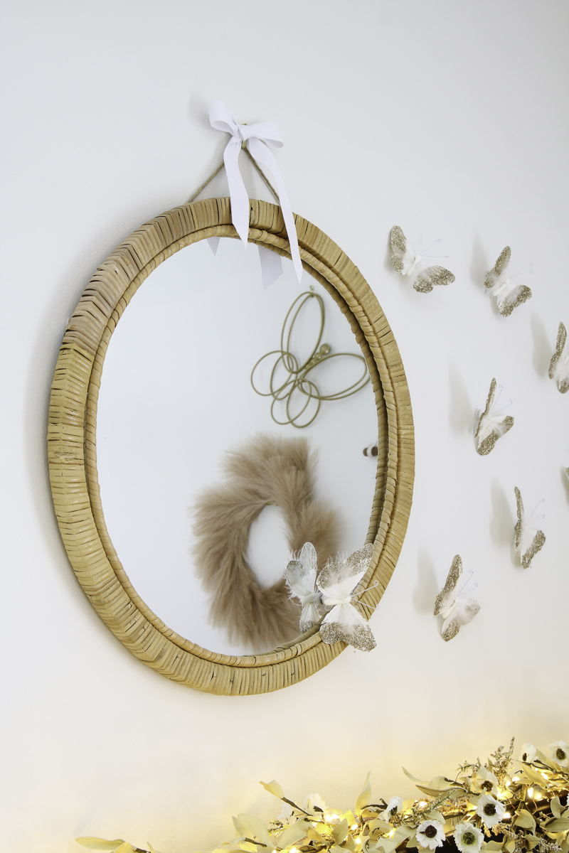 Preteen boho minimalist bedroom  above the bed wall decor of rattan mirror and Pottery Barn butterflies