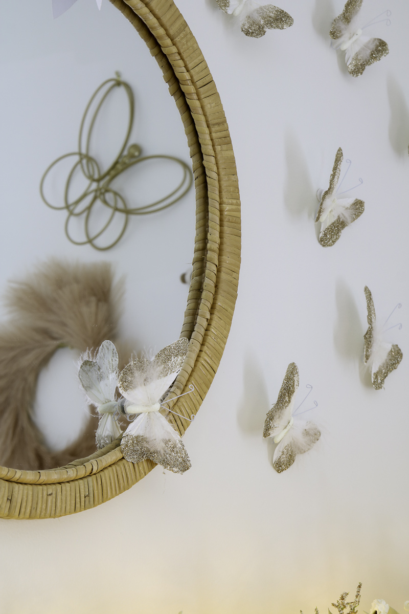 Preteen boho minimalist bedroom  above the bed wall decor of rattan mirror and Pottery Barn butterflies