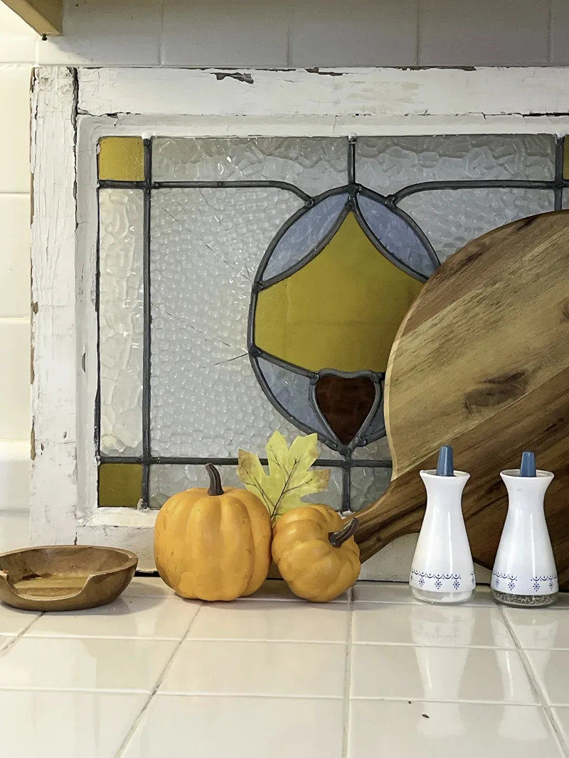 Display of orange mini pumpkins and autumn leave in a kitchen