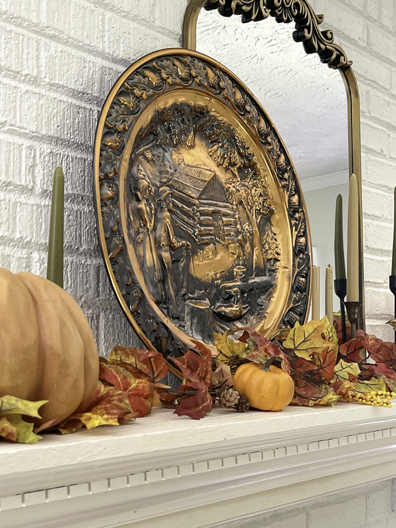 Vintage copper platter decorations for fall on the fireplace mantel