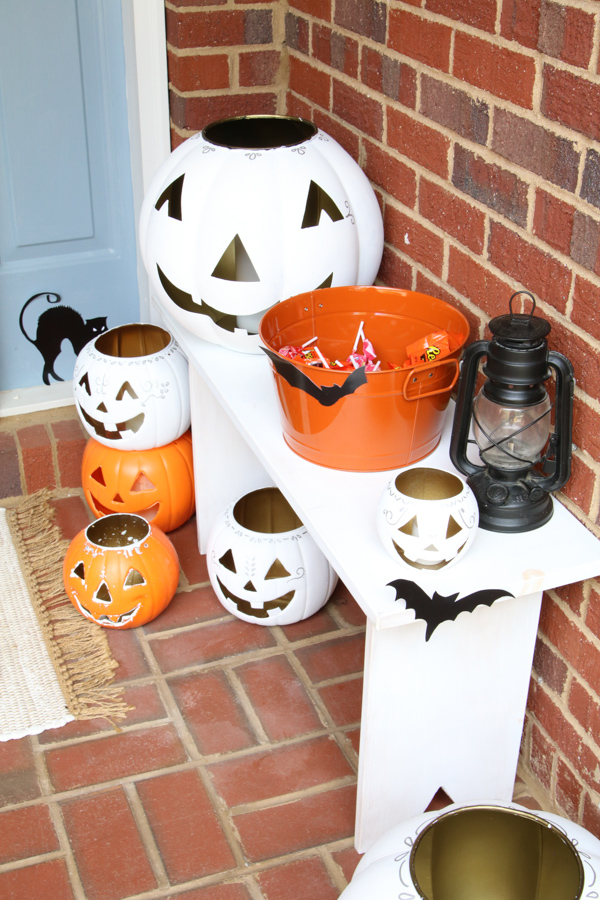 Retro front porch decor ideas using white and orange jack o lanterns and silhouettes