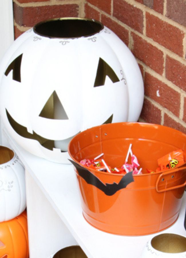 Retro front porch decor ideas using white and orange jack o lanterns and silhouettes