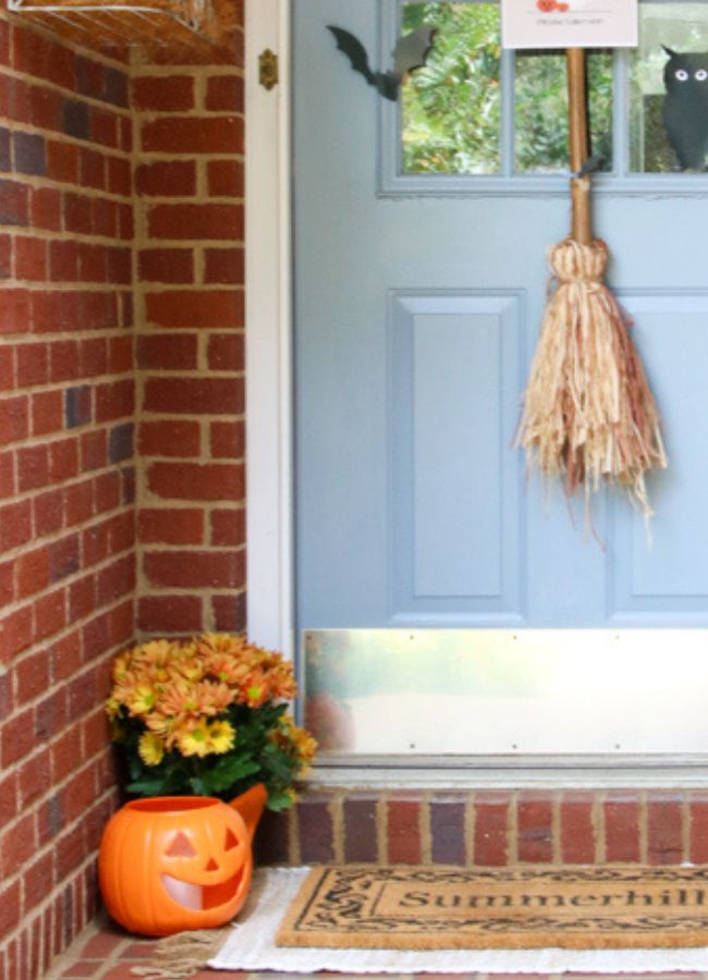 Halloween porch decor ideas using mums and jack o lanterns, witches broom and silhouettes