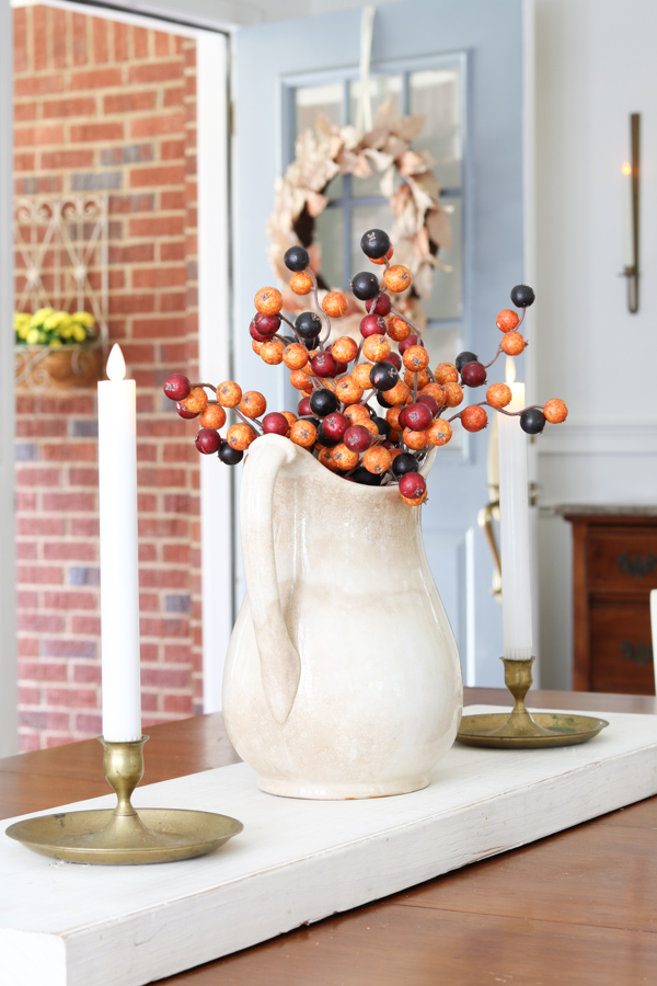 Ironstone pitcher with autumn berries as a centerpiece for our table decorating in neutral and orange fall colors