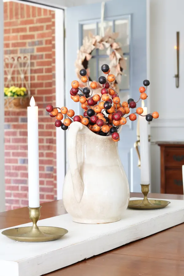 Ironstone pitcher with autumn berries as a centerpiece for our table decorating in neutral and orange fall colors