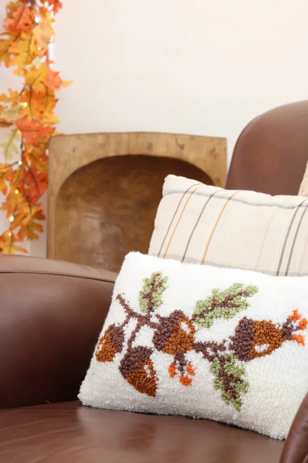 Fall needlepoint pillow used to decorate in neutral and orange fall colors