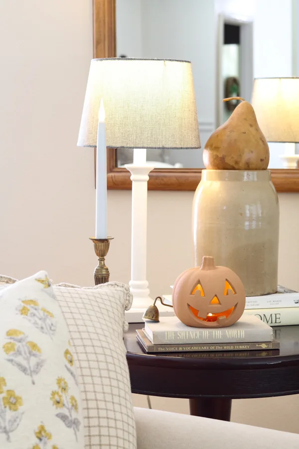 neutral and orange fall decor ideas featuring a terracotta jack-o-lantern