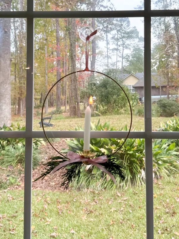 christmas candle wreath hanging in window