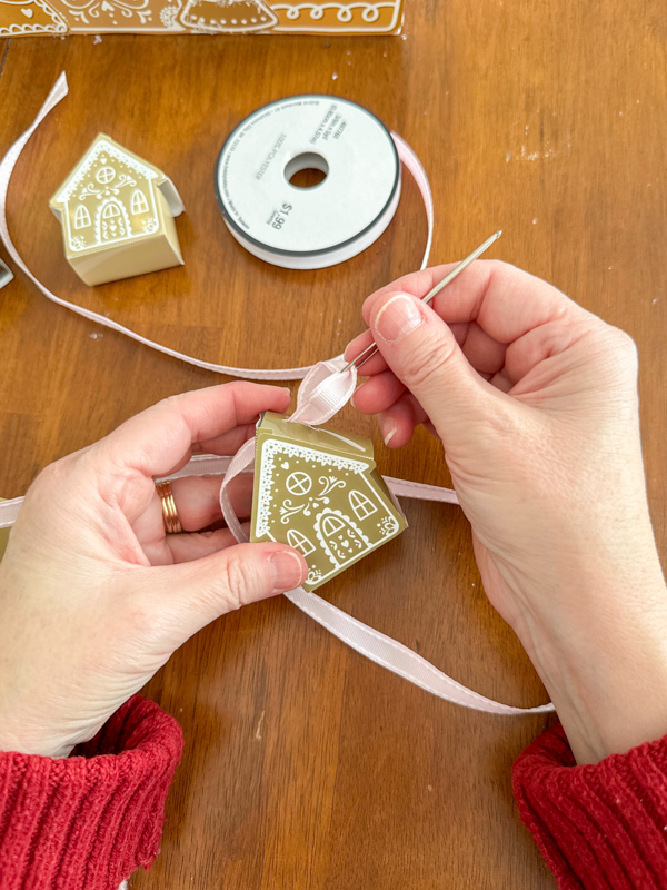 use a yarn needle to thread the ribbon through the houses