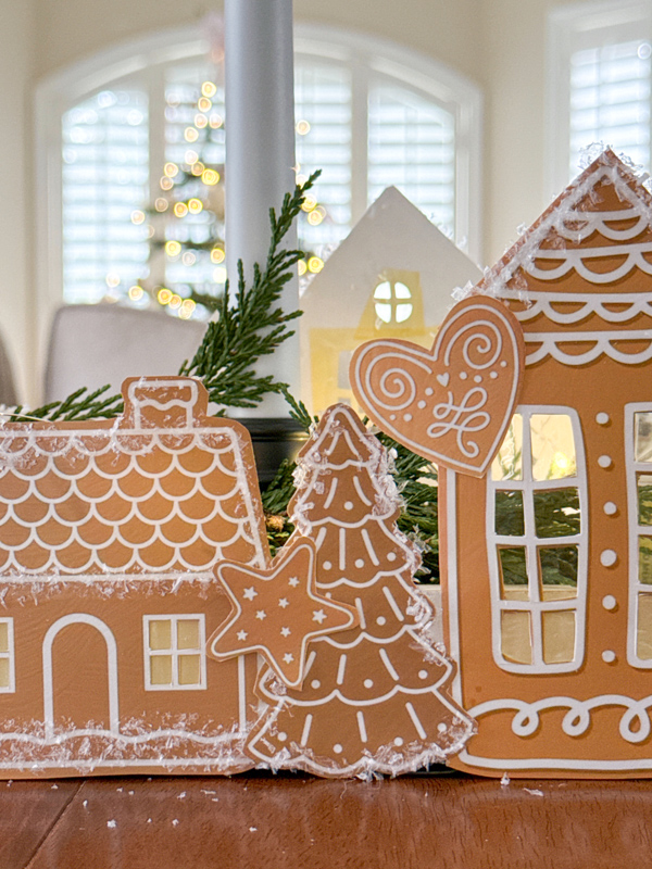 gingerbread village with greenery candles and fairy lights