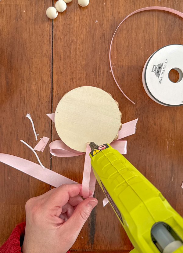 Hot glue a ribbon to the back of the DIY frame ornament for a hanger