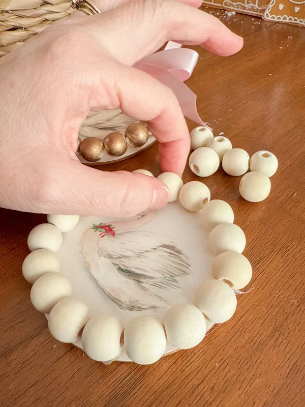 Adding wood beads to a frame ornament