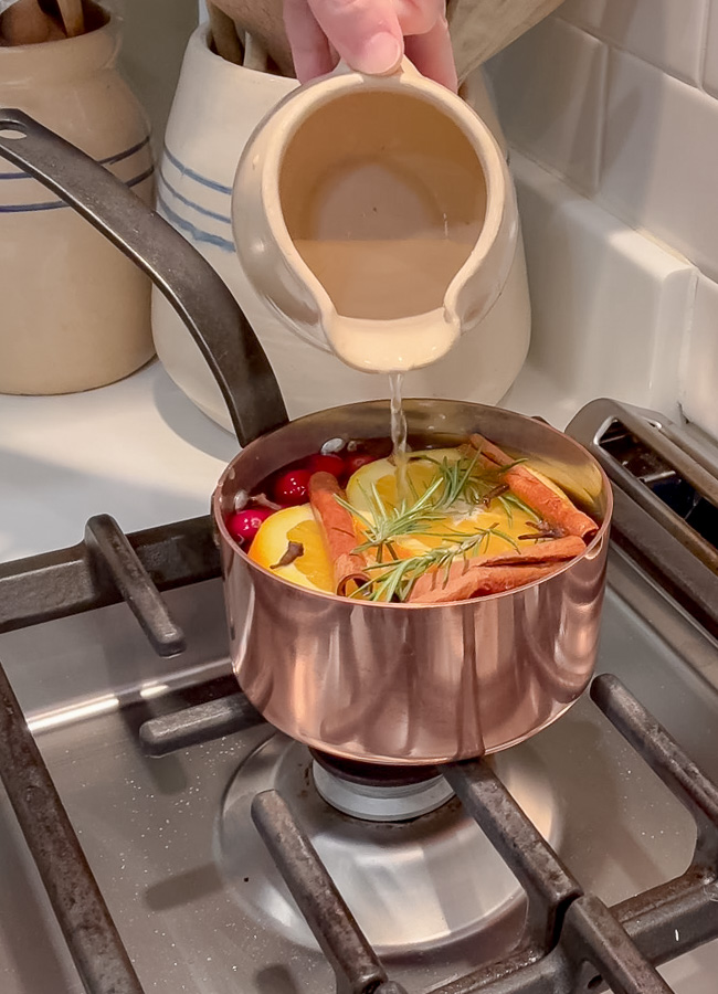 Pouring water over cranberry orange simmer pot.