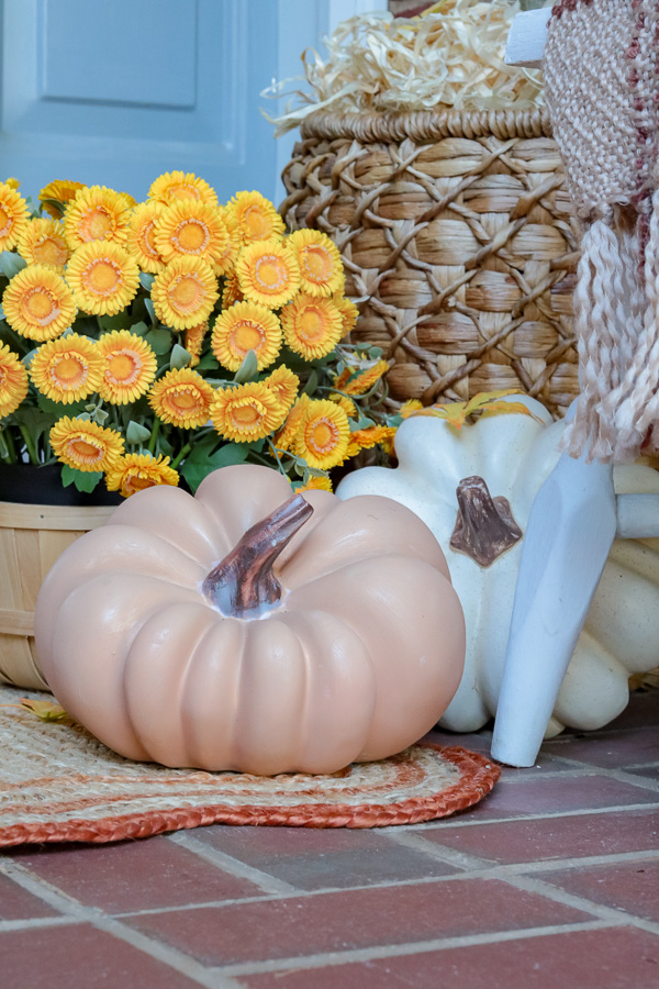 Two faux pumpkins.  one is white and the other is terracotta color