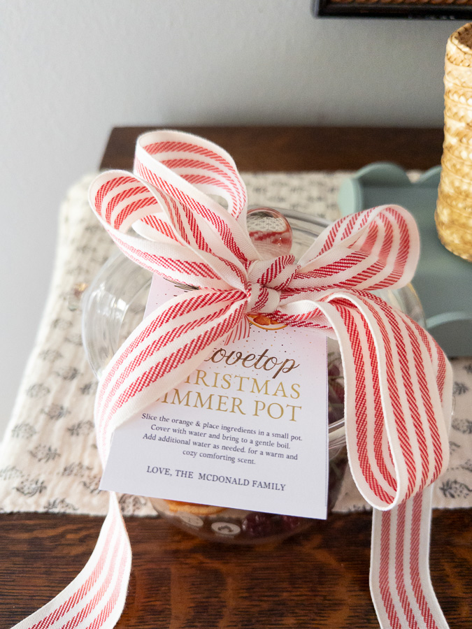 Borosilicate glass pot showing simmering potpourri recipe ingredients with ribbon on top with gift tag
