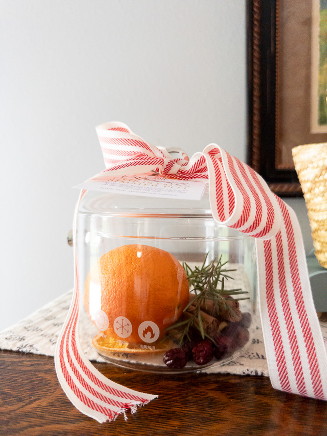 Borosilicate glass pot showing simmering potpourri recipe ingredients inside and a ribbon top with gift tag