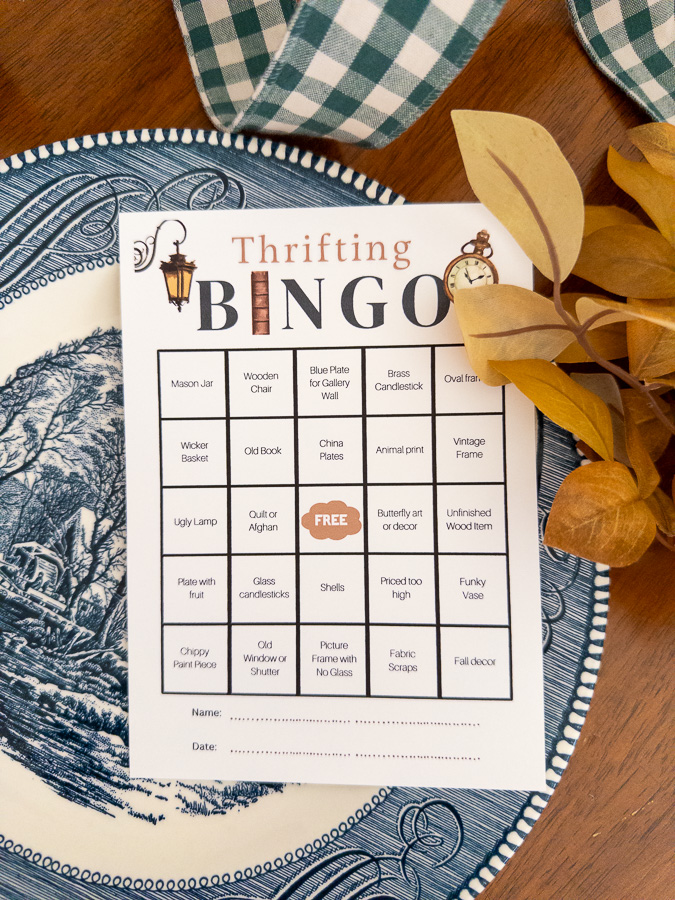 Thrift bingo free printable card sitting on a blue and white book.