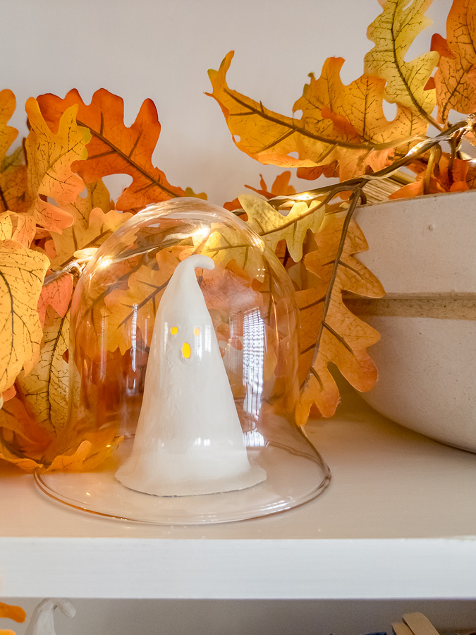 DIY ghost cloche with small glowing ghost under glass dome.