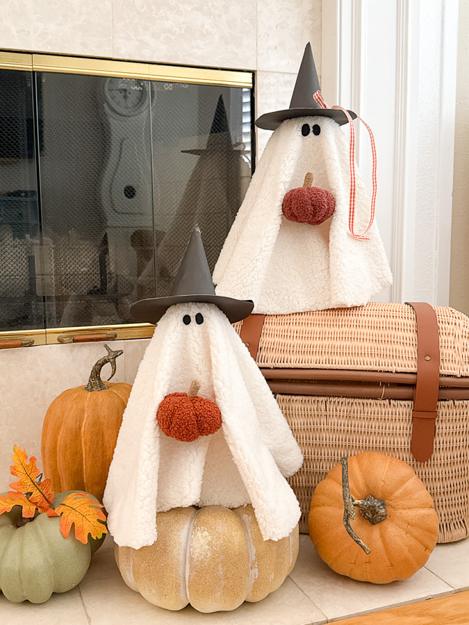 Cute sherpa ghost Halloween decoration sitting on a white mantel with fall accents.