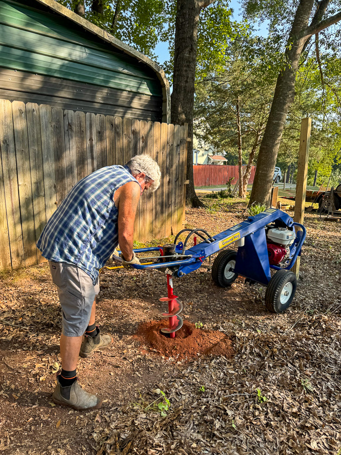 Digging holes with a hole digger rented from Lowes.