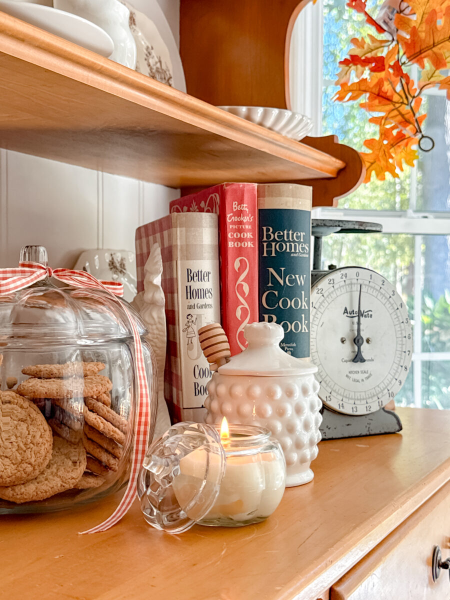 Beeswax candle in pumpkin jar, glass pumpkin cookie jar with ribbon and white milk glass honey pot.