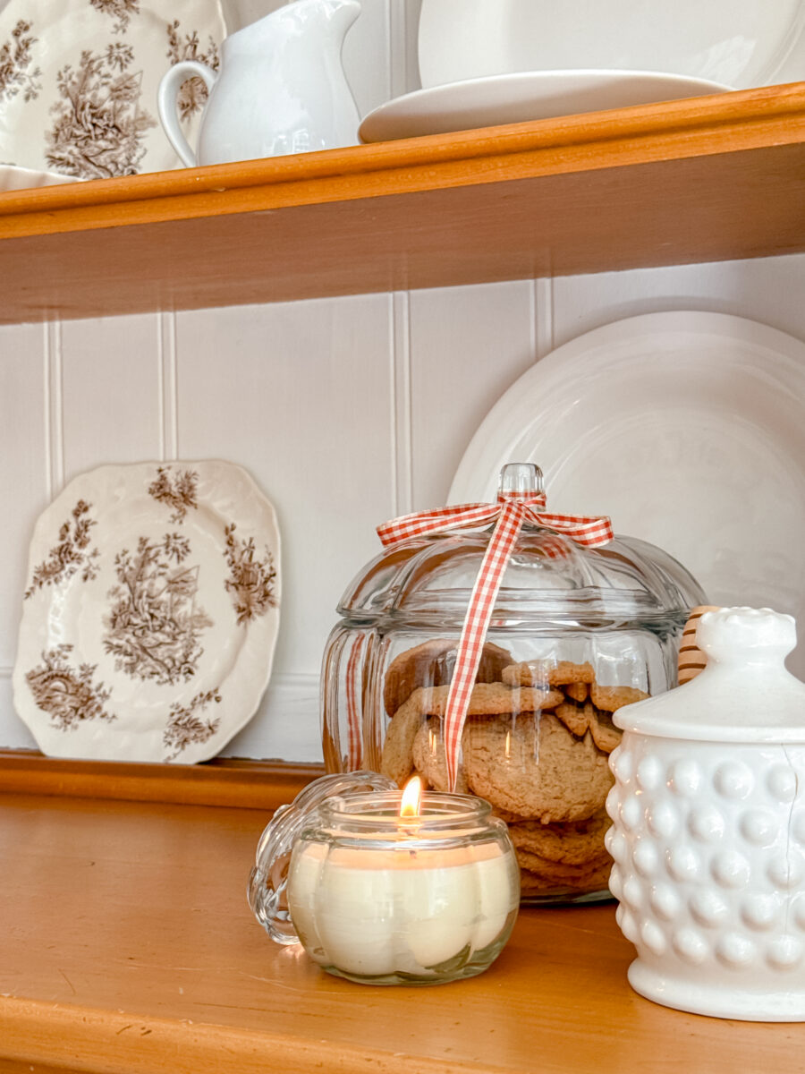 Beeswax candle in pumpkin jar, glass pumpkin cookie jar with ribbon and white milk glass honey pot.