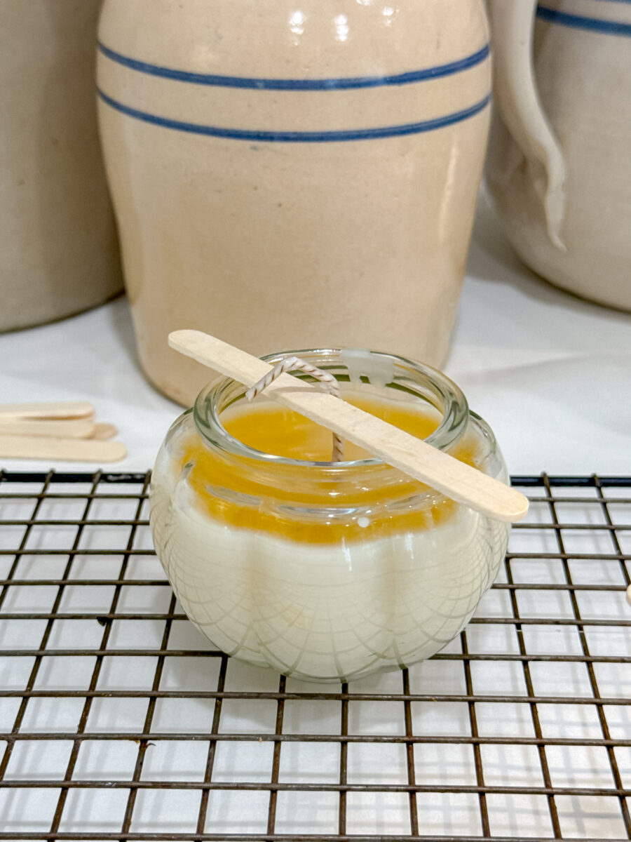 Beeswax candle hardening in a glass jar.