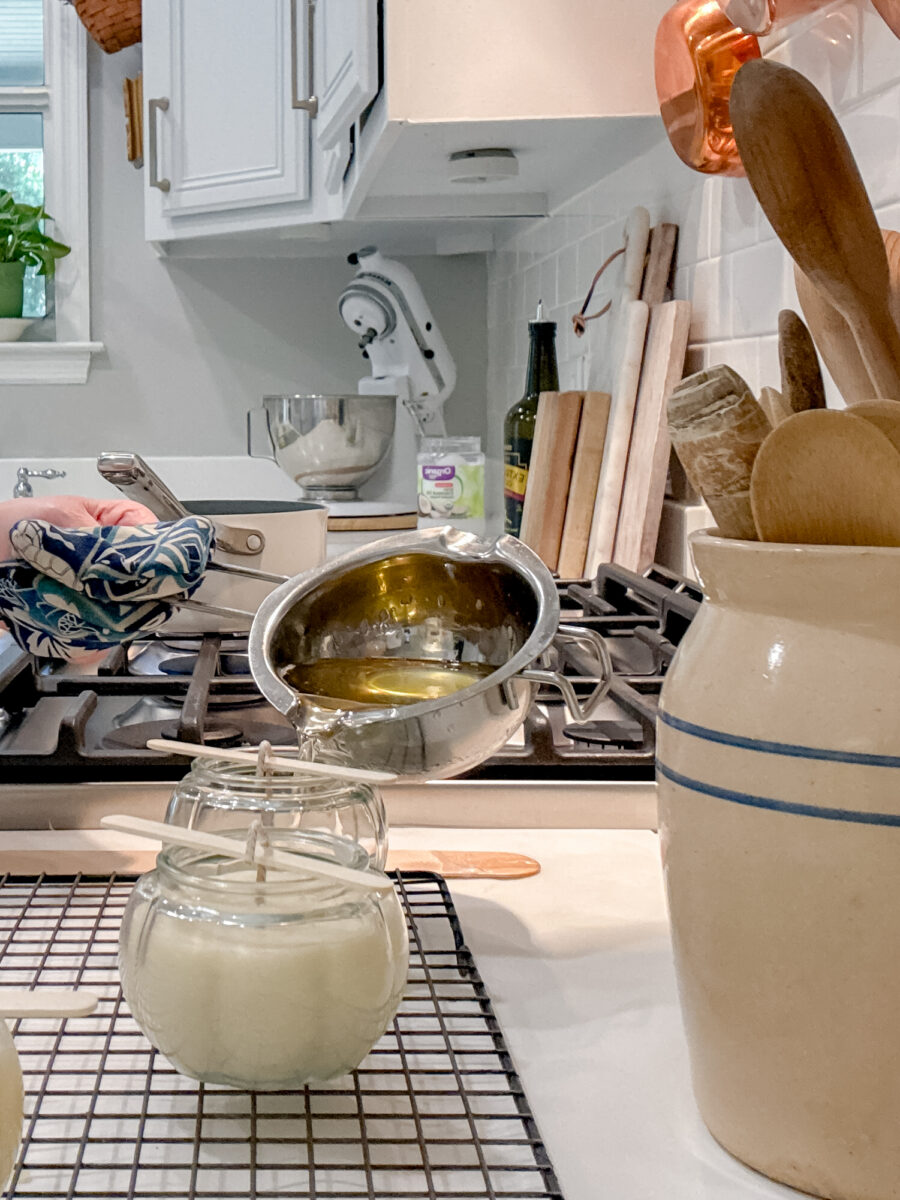 Pouring beeswax in a jar with wick