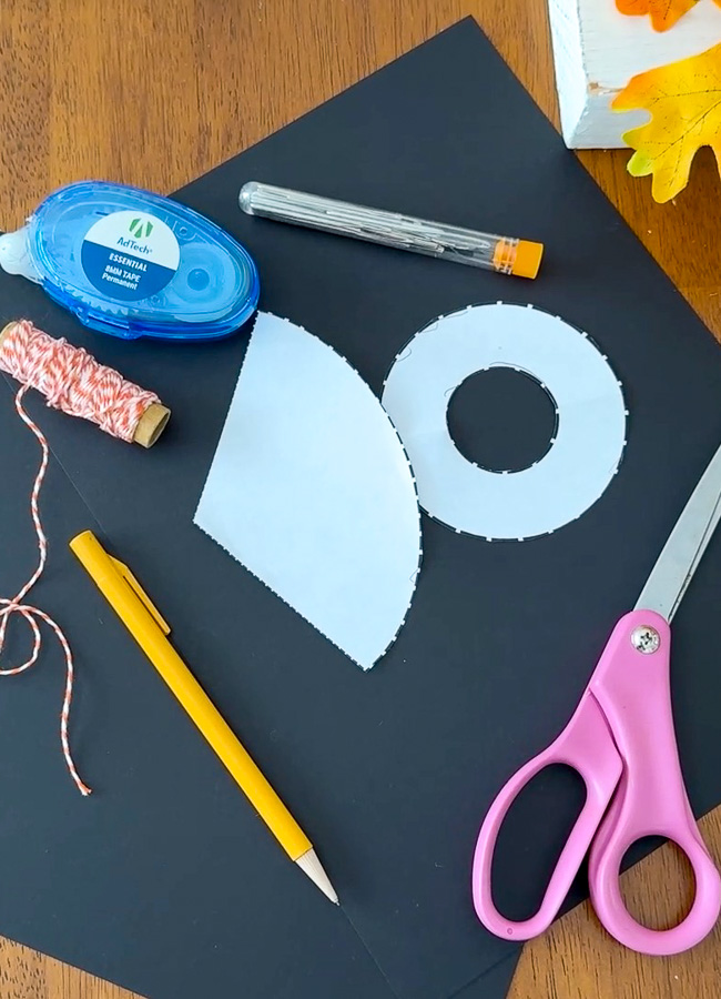 Supplies for making mini paper witch hats including black cardstock, scissors, glue, and printable witch hat pattern.