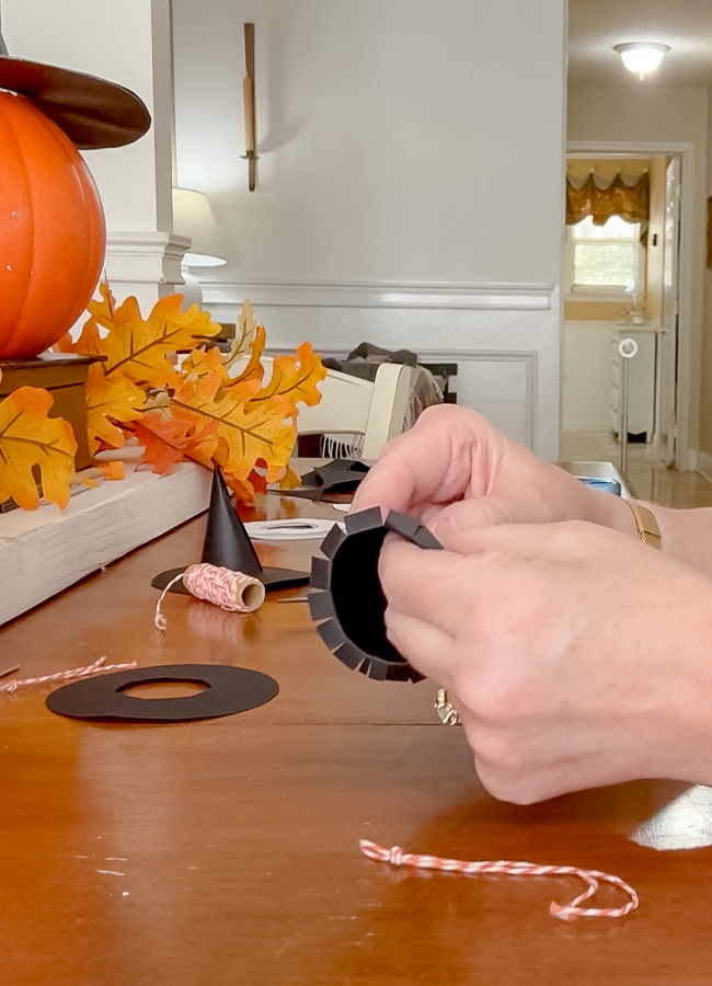 Folding the slits while making a tiny paper witch hat.