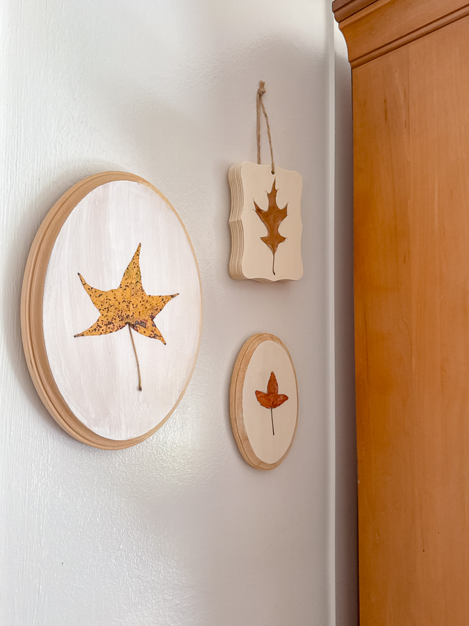 Preserved leaf art on wall next to a hutch that is decorated for fall.