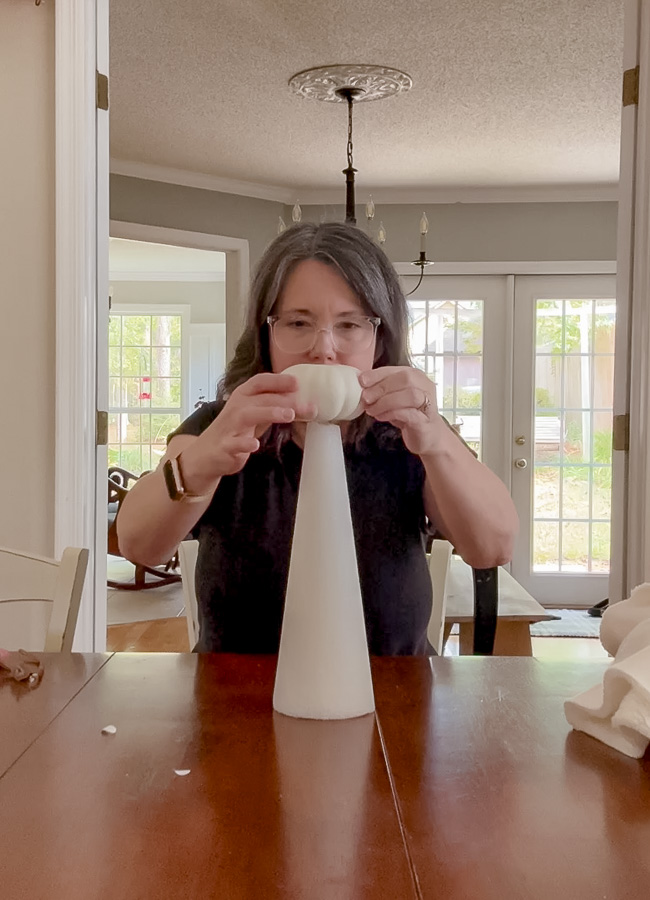 Gluing mini pumpkin upside down on a styrofoam cone