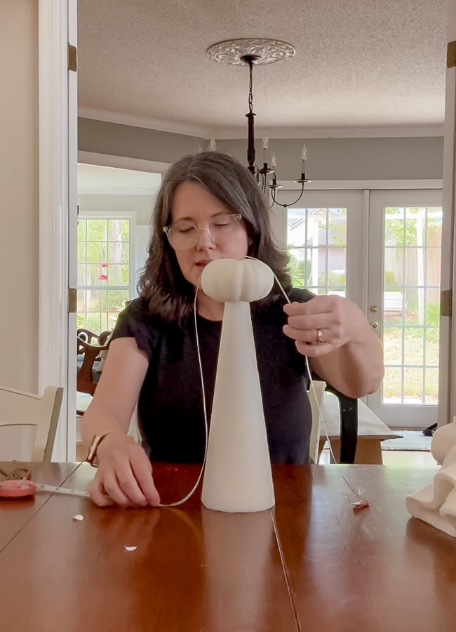 Measuring around the body of the ghost to determine the size of fabric