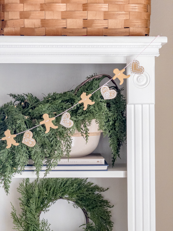 DIY air dry clay gingerbread heart, man and woman garland hanging on a bookcase