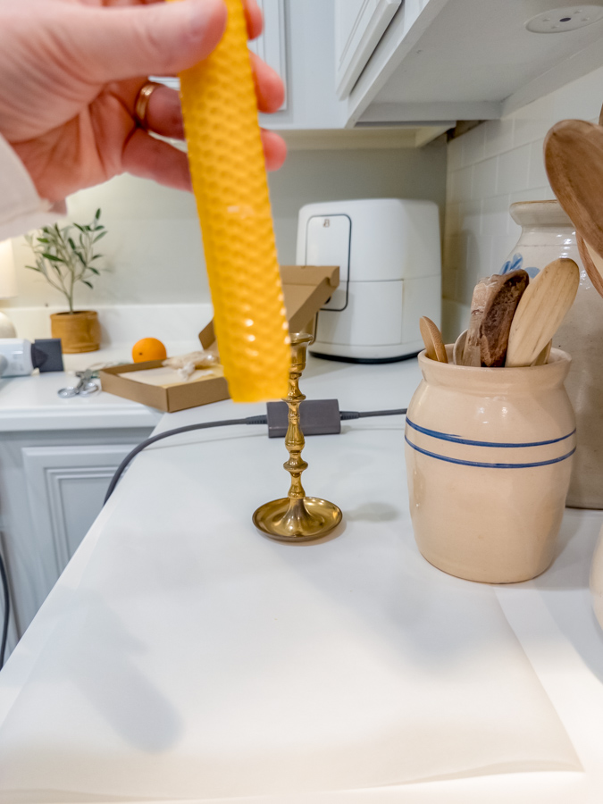 Showing how to form a rolled beeswax candle to fit into a candle holder.