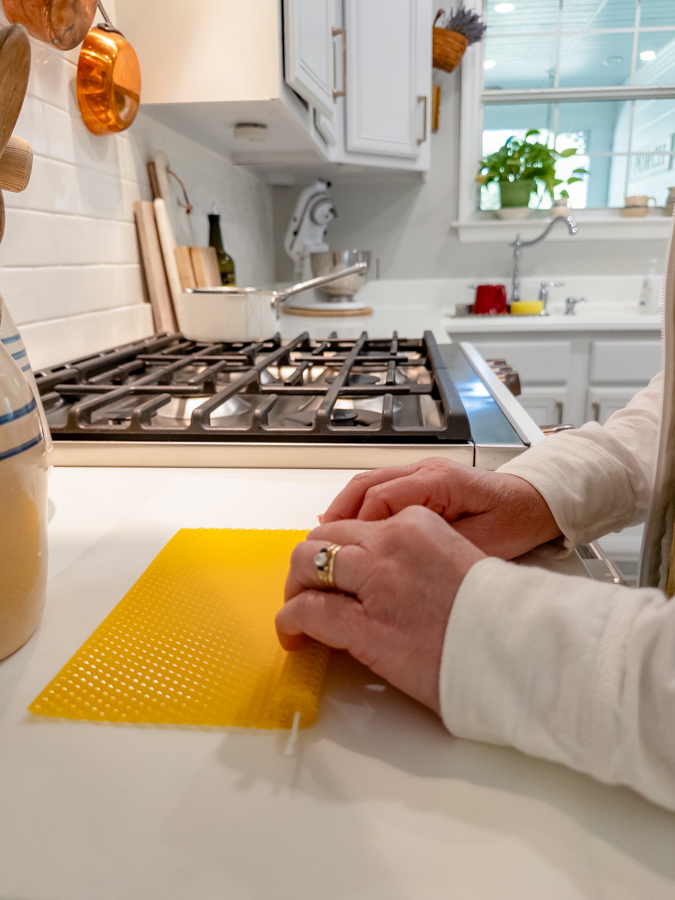 Rolling beeswax sheet to make taper candle.