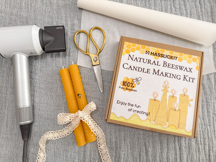 Photo of supplies needed to make rolled beeswax candles.  Beeswax candle making kit, scissors, parchment paper and blow dryer