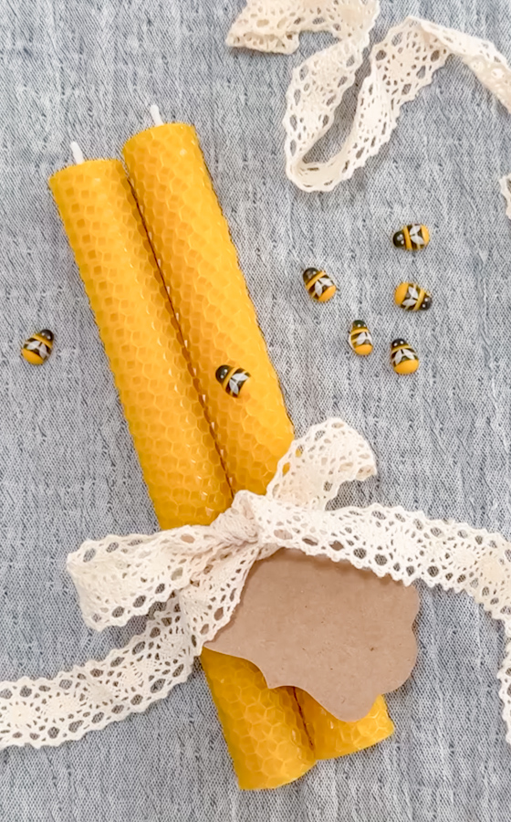 Two rolled beeswax candles tied with lace ribbon and acorded with cute bumble bee decorations.