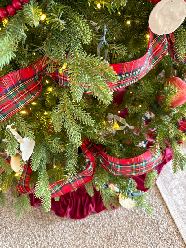 Christmas tree with red, blue and green ribbon and vintage and homemade ornaments.