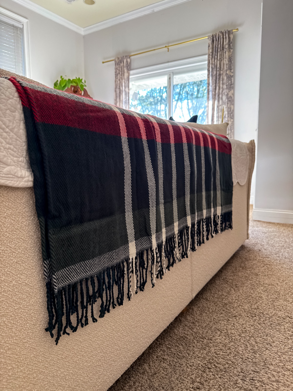 Hunter green, burgundy and white plaid blanket throw added to the back of a couch as an idea to get the Ralph Lauren Christmas style.