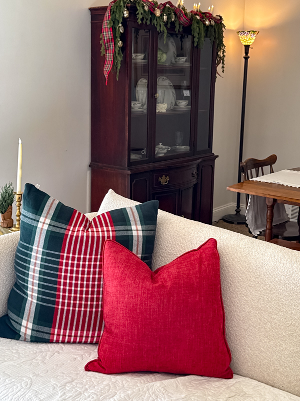Green, burgundy and white plaid pillow on a couch