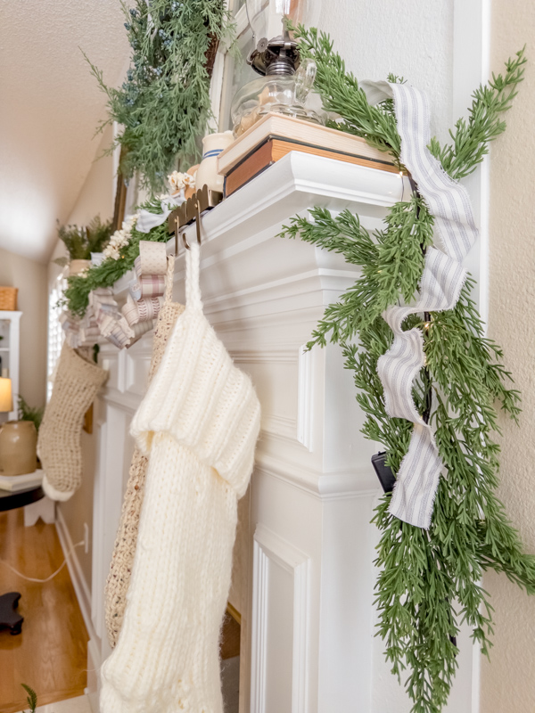 Fireplace mantel decorated with elements from Little House on the Prairie. Garland with ticking ribbon, knit stockings and homemade paper chain.
