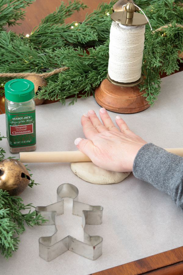 Rolling out clay to make gingerbread men ornaments