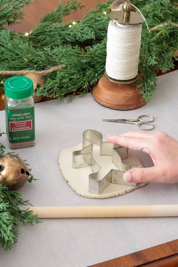 Cutting a gingerbread man out of air dry clay with a cookie cutter