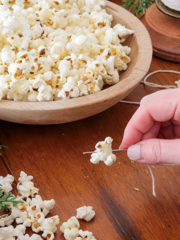 Thread needle through popcorn to make a popcorn garland
