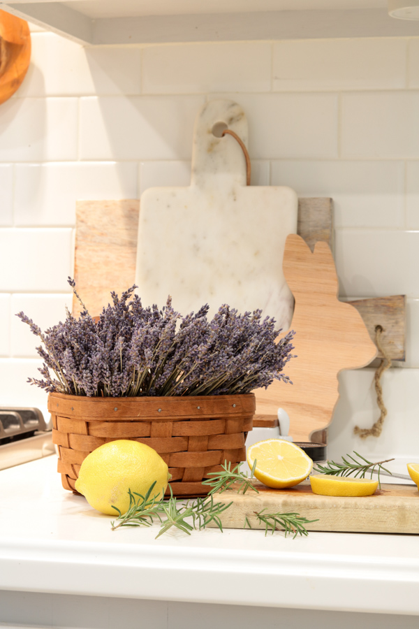 Spring simmer pot supplies - lavender, lemon, rosemary on a counter in front of a stack of cutting boards.