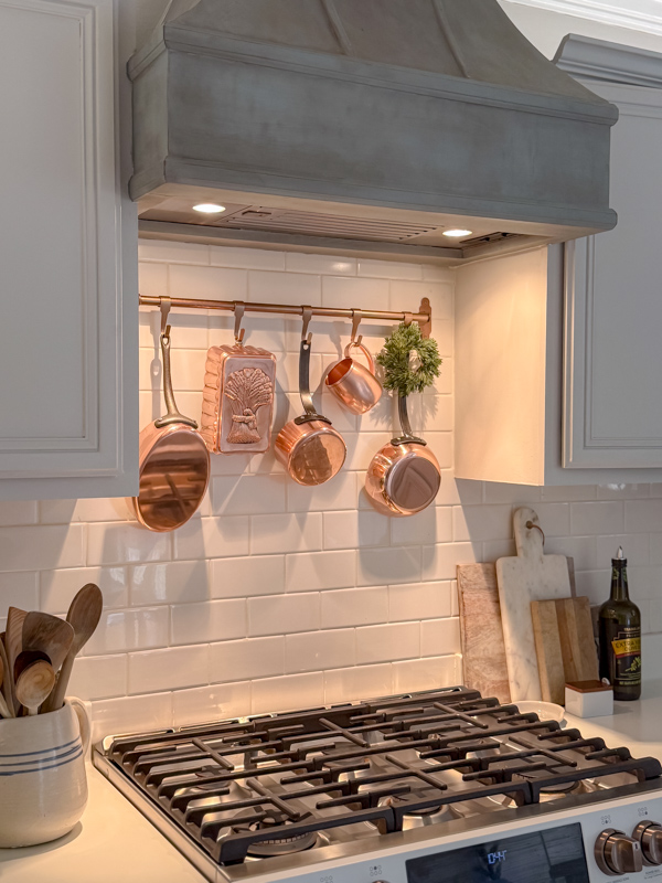 Kitchen decorated for winter leaving mini wreaths from Christmas on the pot holder over the range.