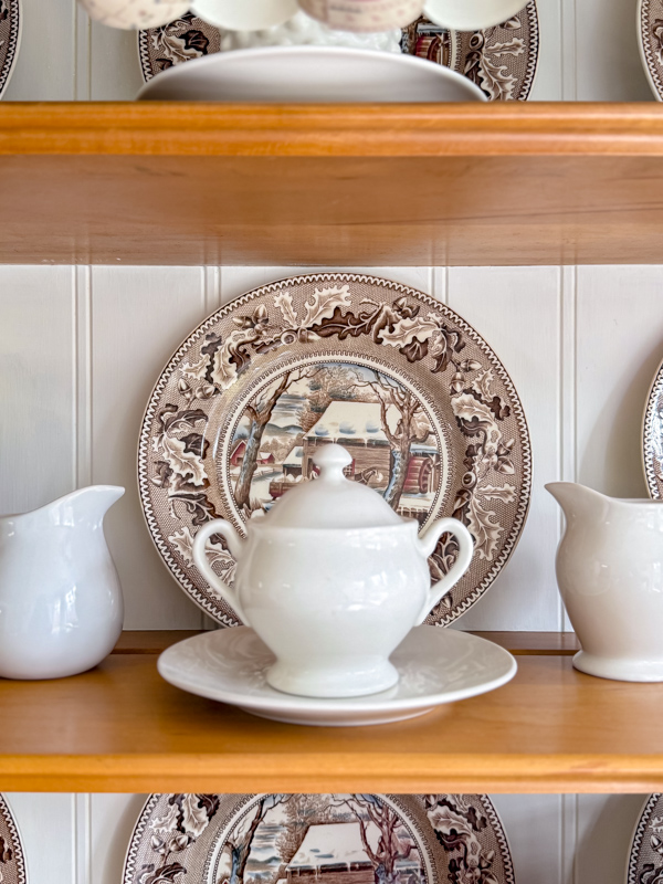 Hutch decorated for winter with snowy scene dishes with Currier & Ives pattern.