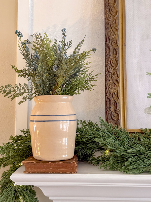 Old crock sitting on an old book with cedar stems in it