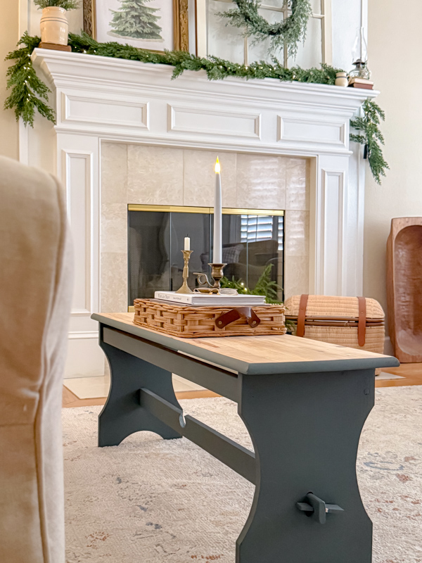 January Home Decor Ideas using candles on a stack of books sitting in a basket tray on a blue coffee table.